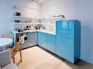 a kitchen with blue cabinets and a table at Center ,gare Montparnasse,5 minute Eiffel tout and Louvre Meusm,amusing place in Paris