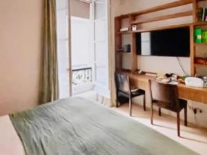 a bedroom with a desk and a bed and a desk and chair at Center ,gare Montparnasse,5 minute Eiffel tout and Louvre Meusm,amusing place in Paris