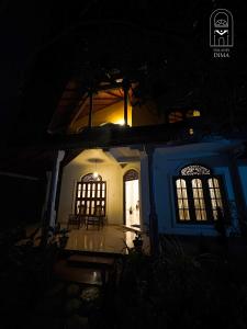 a blue and white house at night with a light at Villas by DIMA in Galle +5 photos