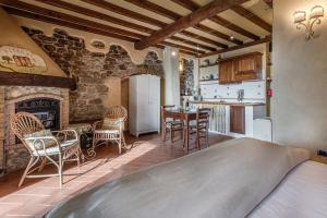 a bedroom with a bed and a kitchen with a fireplace at Agriturismo Podere Campiglia in Pian di Scò