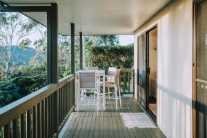 a balcony with a table and chairs on it at Nebesa Tree top villas in Mudgeeraba
