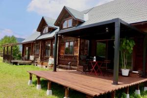 a wooden deck in front of a log cabin at 実と來-mitoki in Takayama +43 photos