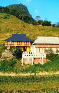 a house on a hill next to a field at Homestay Quyền Linh-Tour Tây Côn Lĩnh in Kon Rung (1)