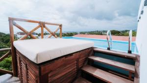 Brisas de ZicatelaAguamiel La Punta的游泳池畔阳台的一张床位