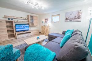 a living room with a couch and a tv at Ferienwohnung Wald in Wald im Pinzgau