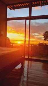 Tamara Monteverde View and Forest Chalet في مونتيفيردي كوستاريكا: غرفة نوم بها سرير ومنظر غروب الشمس من خلال نافذة