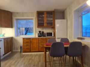 a kitchen with a table and chairs and a refrigerator at Senja Skaland in Melkarhola