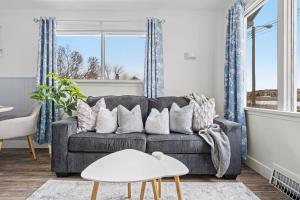 un soggiorno con divano grigio e cuscini di Blue Raptor Family-Friendly 3BR Private Yard a Drumheller