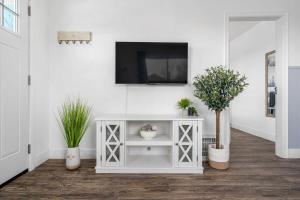 un mobile bianco con una TV su una parete con piante di Blue Raptor Family-Friendly 3BR Private Yard a Drumheller Altre 33 foto