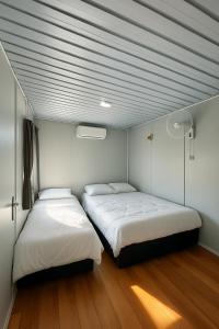 Zwei Betten befinden sich in einem Zimmer mit blauen Decken. in der Unterkunft Ar-Rani Roomstay in Jerantut