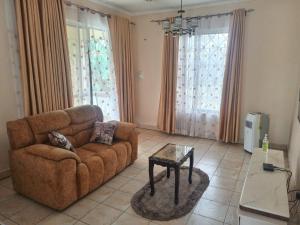 un soggiorno con un divano e un tavolo di Swahili beach home a Mombasa