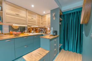 a blue kitchen with wooden cabinets and blue counters at Le Balcon du Brévent - Happy Rentals in Chamonix-Mont-Blanc