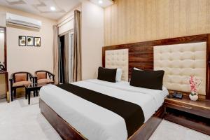 デヘラードゥーンにあるTownhouse Oak Dehradun Court Formerly GK Residencyの大きなベッドと机のある寝室