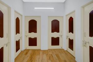 an empty room with white walls and wood floors at Super Hotel O Symbiosis University Nagpur Formerly Royal Villa Inn in Sakardarā