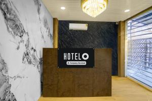 a lobby with a hotel sign on a wall at Super Hotel O Symbiosis University Nagpur Formerly Royal Villa Inn in Sakardarā