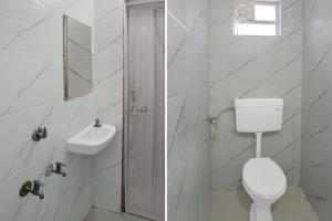 a white bathroom with a toilet and a sink at Super Hotel O Symbiosis University Nagpur Formerly Royal Villa Inn in Sakardarā