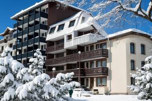 a building in the snow with snow covered trees at Le Balcon du Brévent - Happy Rentals in Chamonix-Mont-Blanc +12 photos