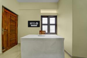KazhakuttamHotel O Engineering College Sreekaryam Formerly B S Plaza的房间里有一张桌子、一把椅子和一扇门