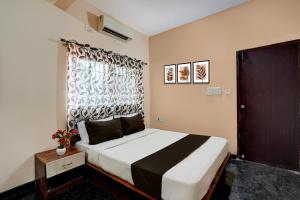 a bedroom with a large bed and a window at Collection O Kammasandra Gate Bus Terminal Formerly Riches Inn in Bayappanhalli