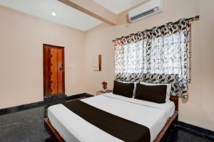 a bedroom with a large bed with a window at Collection O Kammasandra Gate Bus Terminal Formerly Riches Inn in Bayappanhalli +22 photos