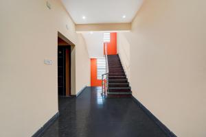 a hallway with stairs in a building with orange walls at Collection O Kammasandra Gate Bus Terminal Formerly Riches Inn in Bayappanhalli
