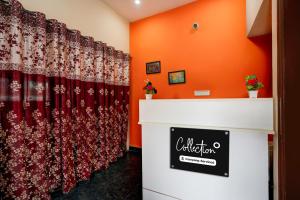 a room with orange walls and a red curtain at Collection O Kammasandra Gate Bus Terminal Formerly Riches Inn in Bayappanhalli
