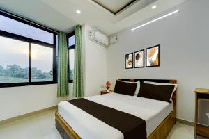 ErumeliHotel O Erumeli Bus Terminal Kottayam Formerly Pious B Residency的一间卧室，里面有一张床和一扇大窗户。 更多22张照片