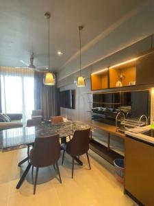 Una cocina y un comedor con mesa y sillas. en Antara Genting by Enigma 2BR, High Floor, en Genting Highlands