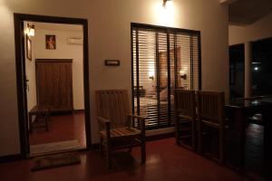 马拉利库兰Marari Ebin Charlys的有两把椅子和一扇窗户的客厅