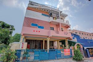 a building with a blue fence in front of it at Hotel O Tiara Grand in Chennai +5 photos