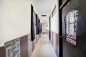 a hallway with paintings on the walls and a door at Collection O Jhalwar Road in Kota