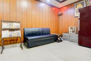 a leather couch in a room with wooden walls at Collection O Jhalwar Road in Kota