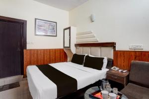 科塔Collection O Jhalwar Road的一间酒店房间，里面有一张床和一把椅子 更多24张照片