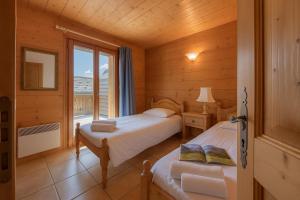 Terrasse Bec Rouge Montroc - Happy Rentals في شامونيه مون بلان: غرفة نوم بها سريرين ونافذة