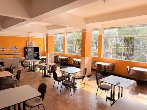 a restaurant with tables and chairs and windows at Hotel Alojamento AS in Americana