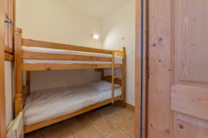 Terrasse Bec Rouge Montroc - Happy Rentals في شامونيه مون بلان: غرفة نوم بها سريرين بطابقين في الغرفة