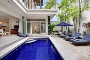 an indoor pool with blue tiles in a house at Villa Alba in Seminyak