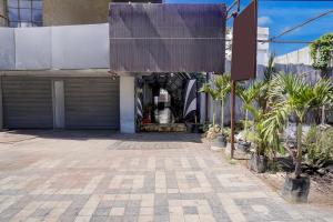 un edificio con un garage con palme di fronte di Super Collection O Paithan Gate Formerly Rajlaxmi Executive ad Aurangabad Altre 23 foto