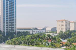 河内A89 Premier Sky Residence Stadium View的享有棕榈树和建筑的城市美景