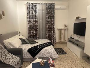 mała sypialnia z łóżkiem i telewizorem w obiekcie Adriana w mieście Corsico