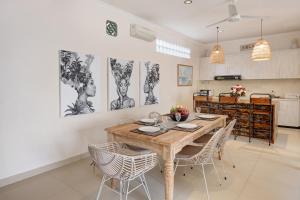 a dining room with a wooden table and chairs at Villa Alba in Seminyak +25 photos