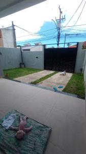 マリカーにあるCasa aconchego - praia, trilhas, comercio, praçaの庭のマットの上に横たわるテディベア +17枚の写真