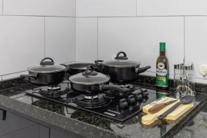 Suíte - Ideal para conexões no aeroporto de Guarulhos في جوارولوس: قدور اثنين جالسين على موقد في مطبخ