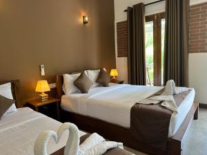 Una habitación de hotel con dos camas y una ventana. en Hotel Heladiv, en Anuradhapura 65 fotos más