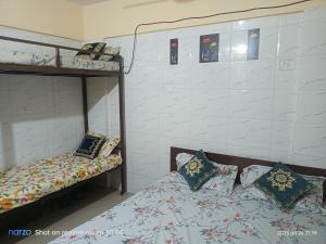 AC Bed And Breakfast At Pushpanjali Phase 2 ,Ovale ,Ghodbunder Road Thane West في ثين: غرفة نوم مع سرير ورف مع الوسائد