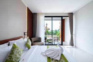 Un dormitorio con una cama con un cisne encima. en Three Brothers Munggu Suites Villas and Restaurant, en Pererenan 77 fotos más