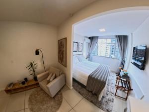 a bedroom with a bed and a couch and a window at Studio 929 Gold Star 400m Ferry to Rio 1Gb Wi-Fi in Niterói
