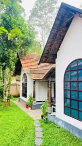 Munroe Plackal Heritage في Munroe Island: منزل أبيض مع مسار يؤدي إلى الفناء