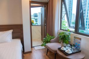 河内A89 Premier Sky Residence Stadium View的一间带床、桌子和窗户的酒店房间
