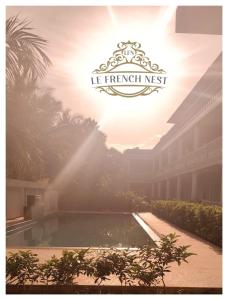 a logo for a hotel with a fountain in a courtyard at Le French Nest in Puducherry